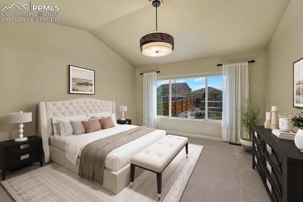 Primary bedroom retreat has vaulted ceiling and en suite bathroom. Virtually staged