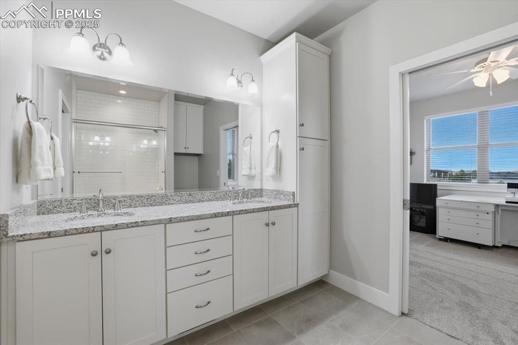 This spacious bathroom has dual vanities and is connected to both the second and third main-floor bedrooms. 