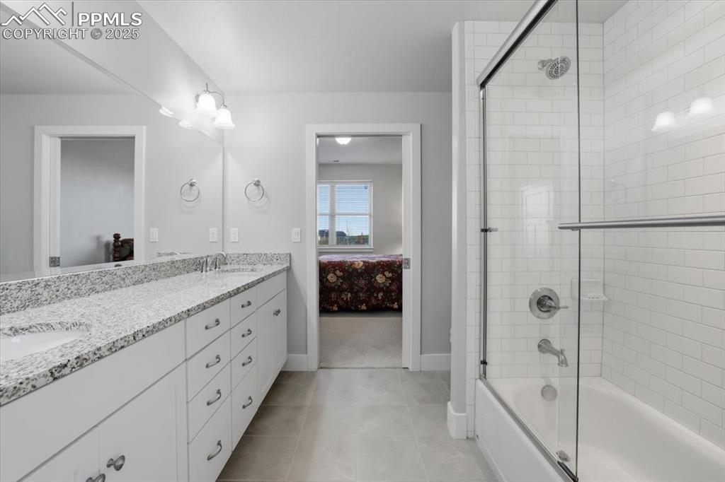 This spacious basement-level bathroom features a tub/shower combo and dual vanities. 