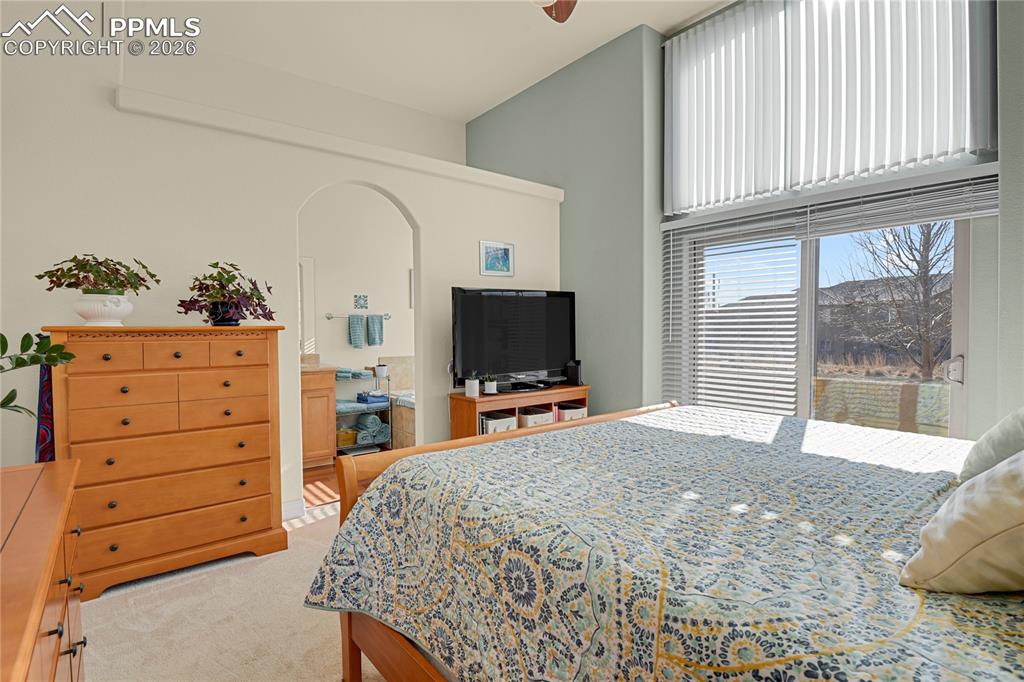 Primary main level bedroom, showing entry to attached Primary bath. Slider to enclosed front patio.