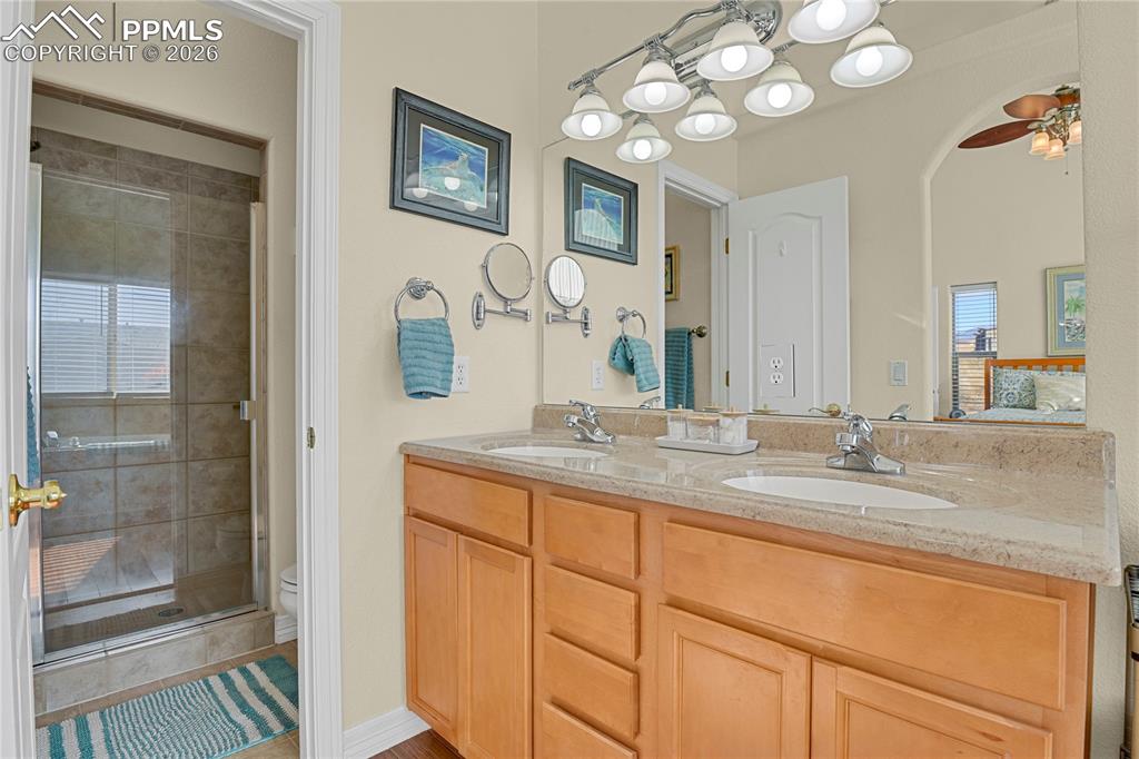 Main level Primary bathroom showing double sinks & entry door to large shower & toilet.
