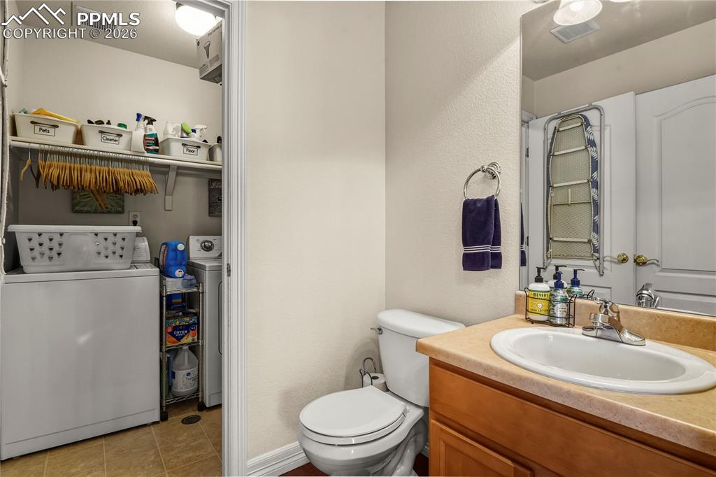 Main level bathroom, showing attached laundry room with door.