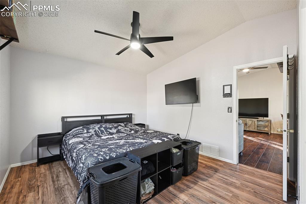 Bedroom with, dark wood finished floors, ceiling fan, and a textured ceiling