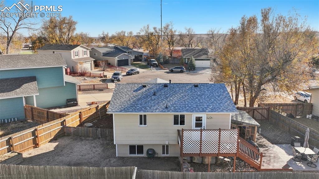 Back of house with a residential view, a shingled roof, a fenced backyard, and a wooden deck