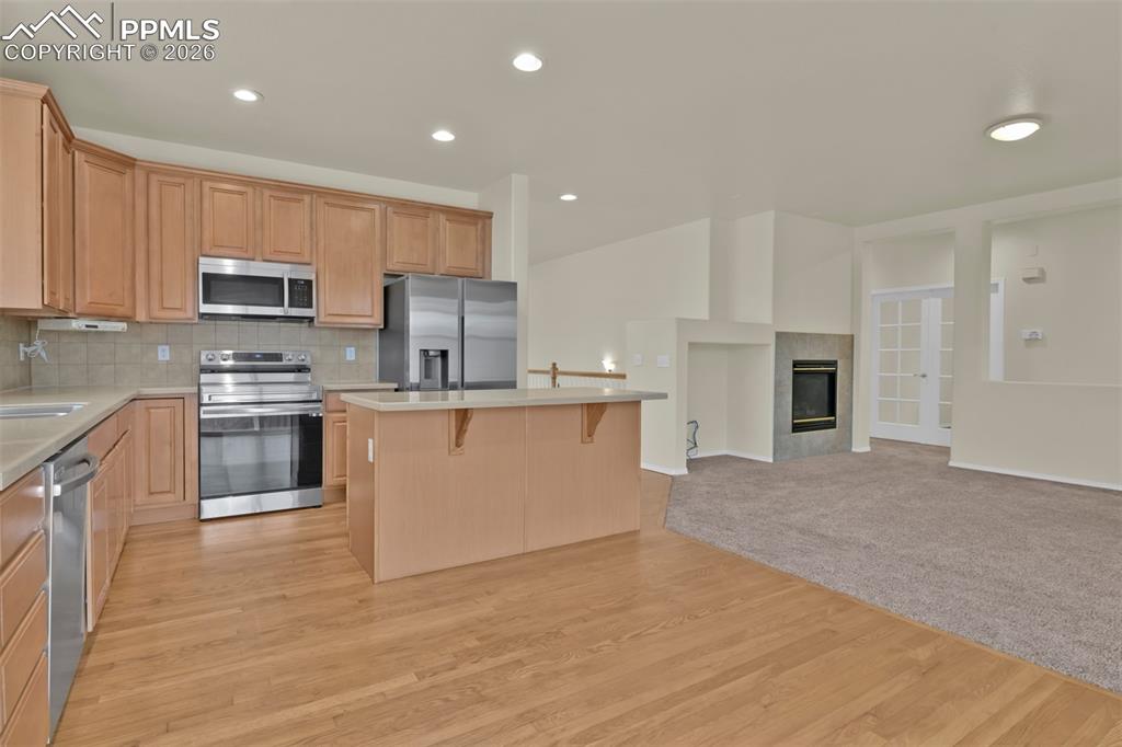 Spacious kitchen with island, stainless steel appliances and eating nook