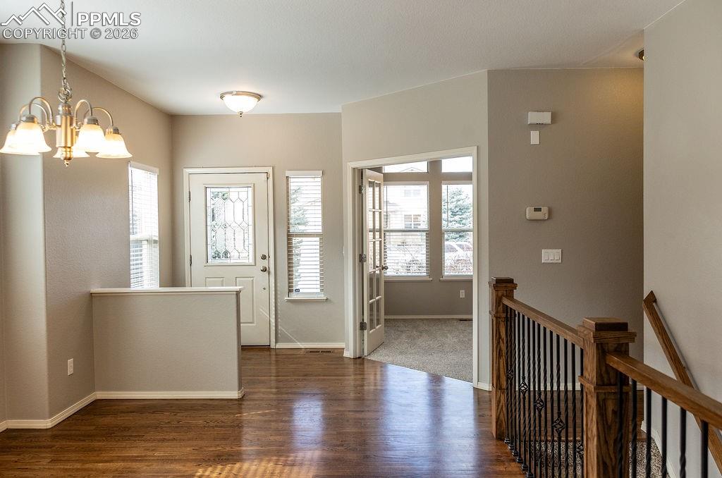Foyer entrance featuring dark wood-style floors and a chandelier
