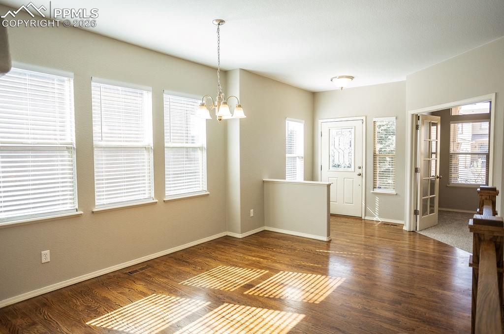 Entrance foyer with a chandelier and dark wood-style floors