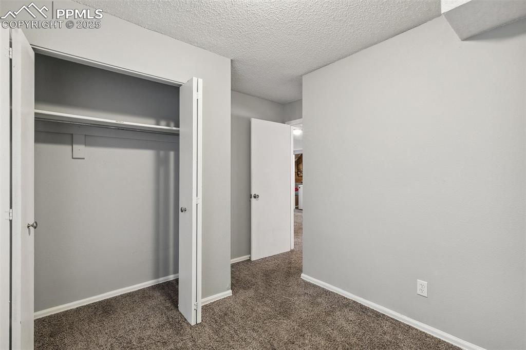 Unfurnished bedroom with carpet, a closet, and a textured ceiling