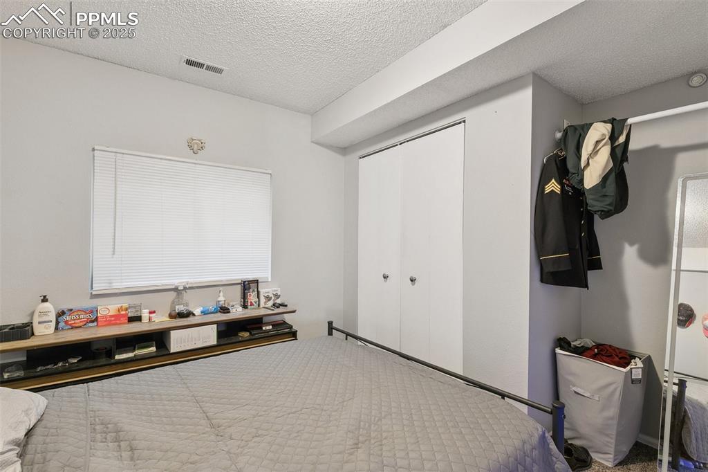 Bedroom featuring a textured ceiling and a closet