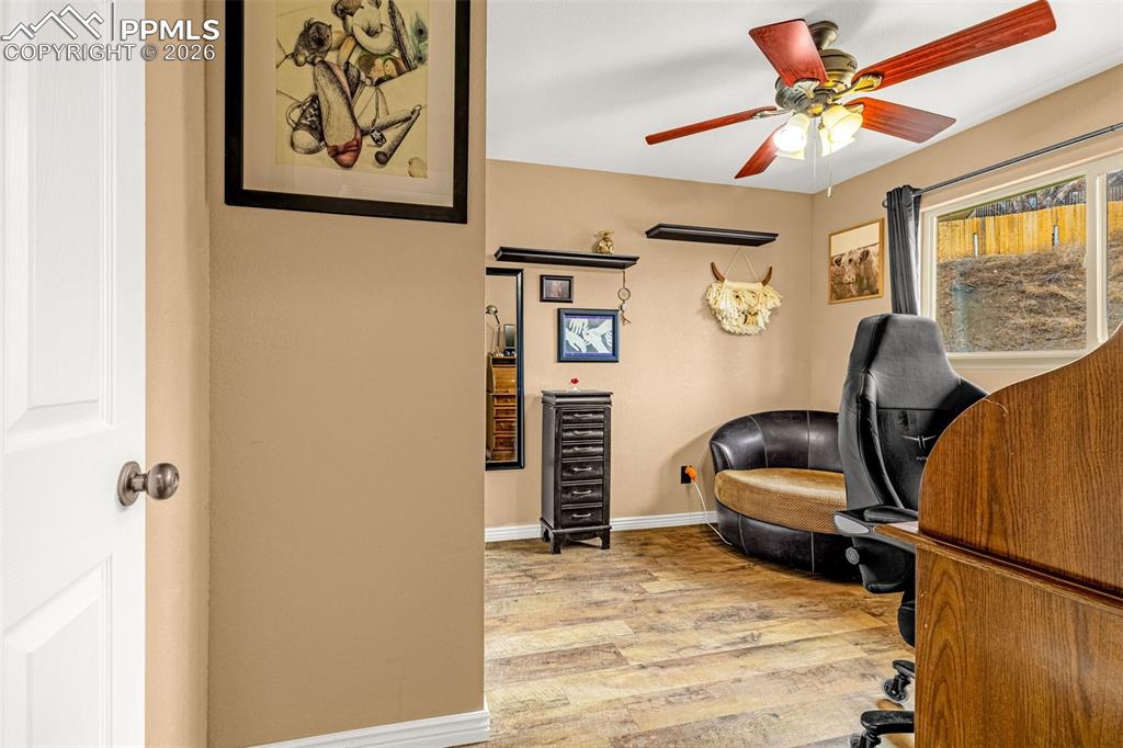 Office with light wood-style flooring, a ceiling fan, and wine cooler