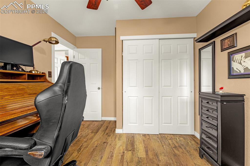 Office area with a ceiling fan and wood finished floors