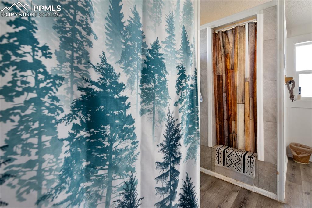 The full bath has a shower with curtain and wood floors!