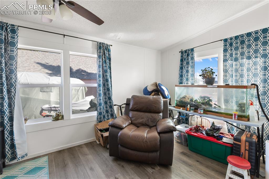 A bedroom with wood floors and a ceiling fan!