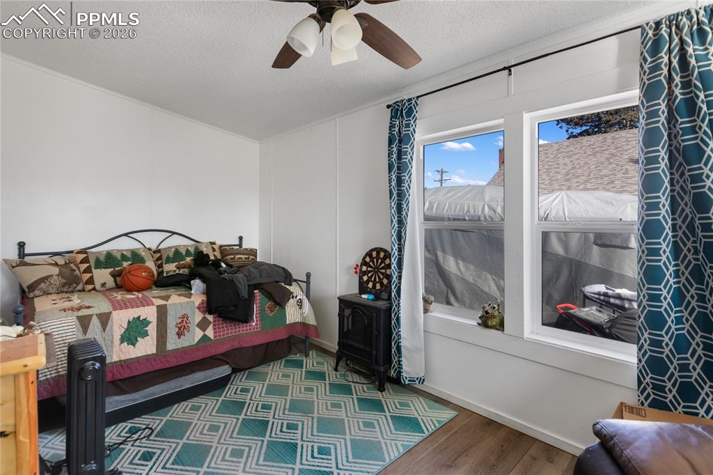 A bedroom with wood floors, and a ceiling fan!