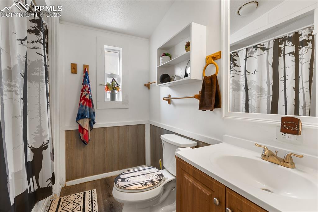 The full bath with wainscoting, vanity, and dark wood flooring!