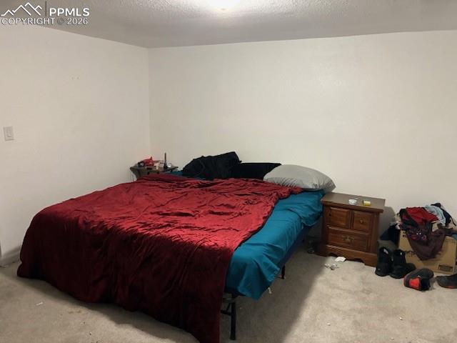 Bedroom with carpet and a textured ceiling