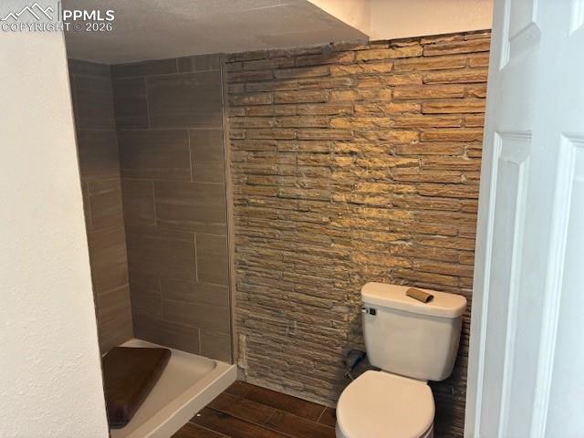 Bathroom featuring a stall shower, wood tiled floors, and a textured ceiling