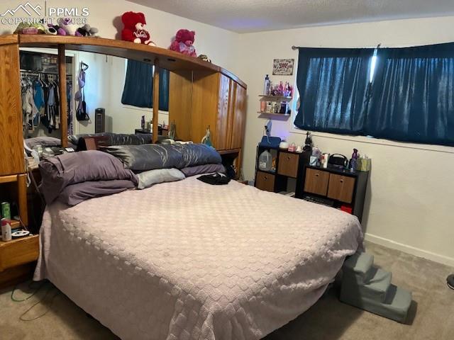 Bedroom featuring carpet, a textured ceiling, and arched walkways