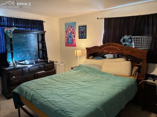 Bedroom featuring carpet floors and a textured ceiling