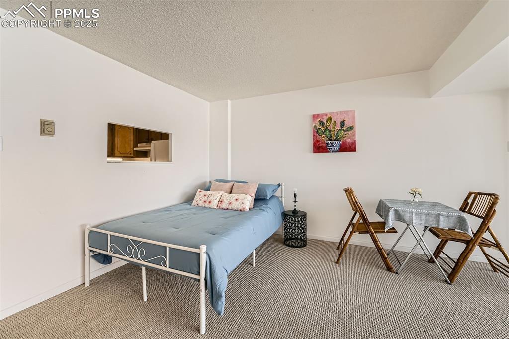 Bedroom featuring carpet and a textured ceiling