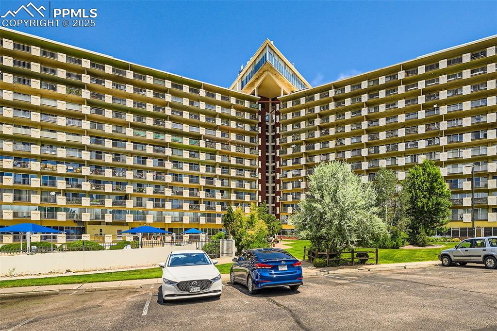 View of apartment building / complex featuring uncovered parking