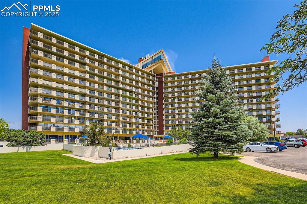 View of apartment building / complex with uncovered parking