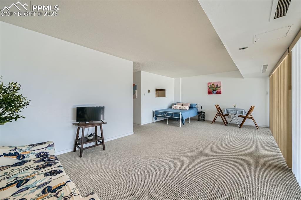 Carpeted living area featuring baseboards