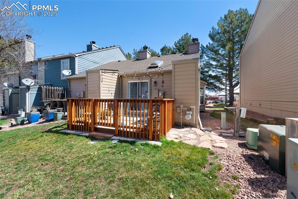 Back of property featuring a community green area, a fenced-in patio, and a chimney