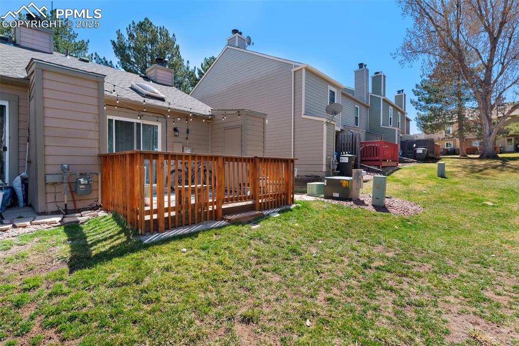 Rear view of house with a lawn, a fenced-in patio, and a chimney