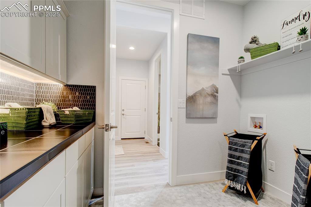 Laundry area with hookup for a washing machine, recessed lighting, and light wood-style flooring
