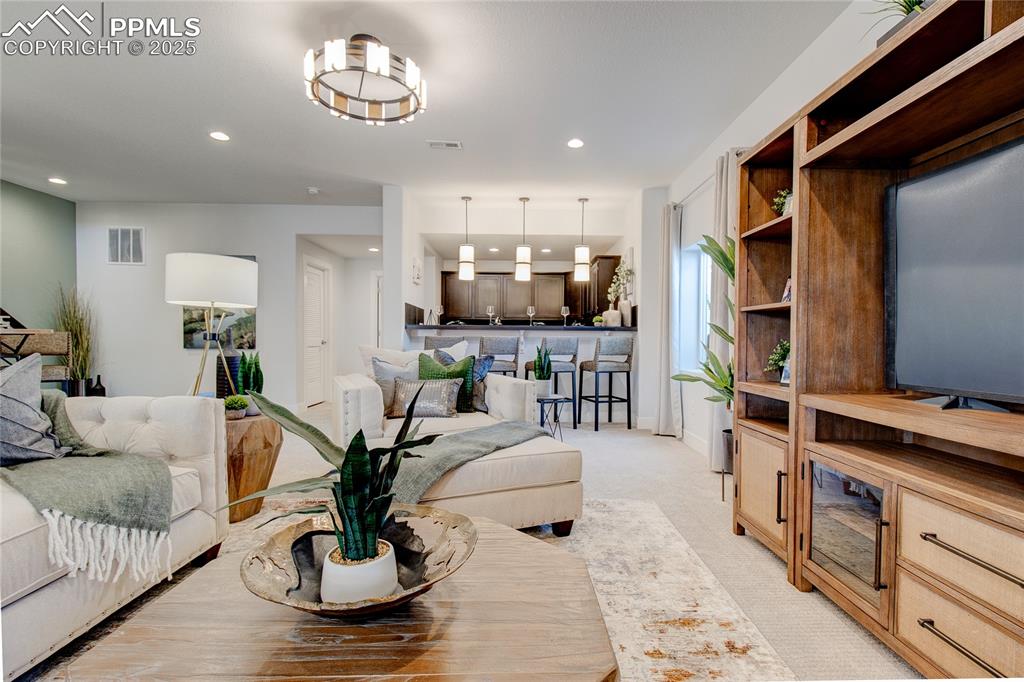 Living area featuring recessed lighting and light colored carpet