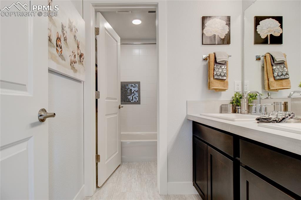 Bathroom featuring vanity, shower / washtub combination, and light tile patterned floors
