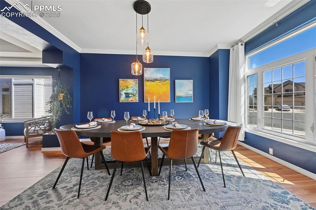 Dining area featuring wood finished floors and crown molding