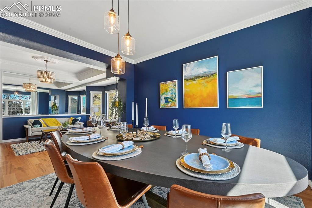 Dining space featuring wood finished floors and ornamental molding