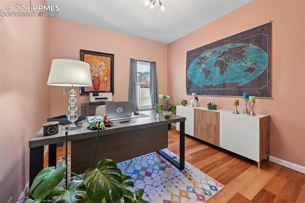 Home office with light wood finished floors and baseboards