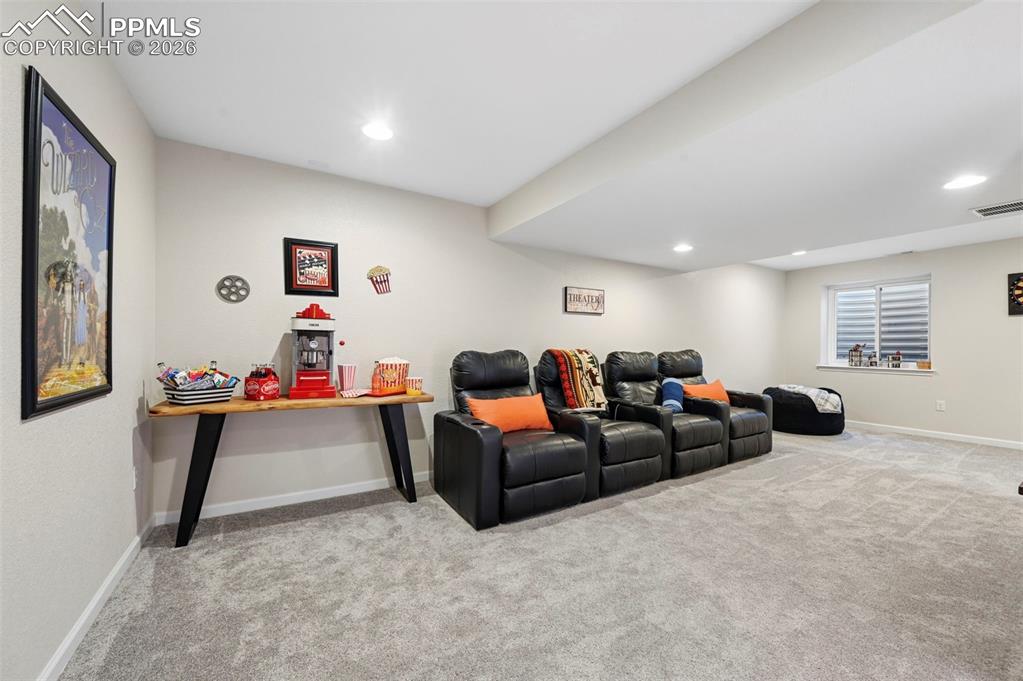 Cinema room with light carpet and recessed lighting