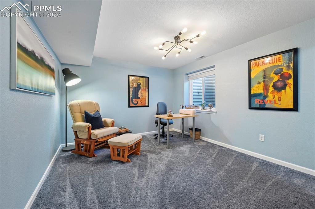 Office space featuring baseboards and dark carpet