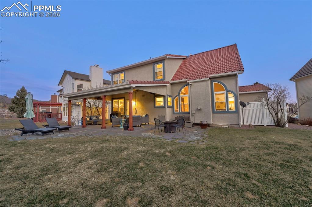 Back of house with a patio, stucco siding, and a tiled roof