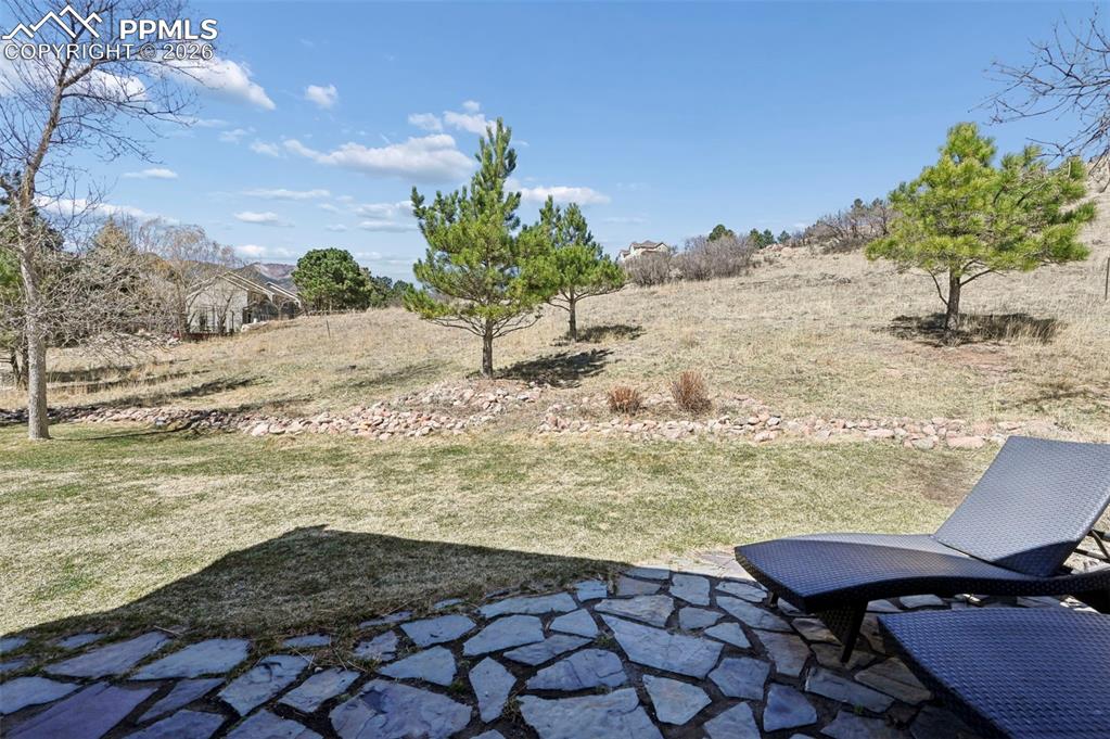 View of grassy yard with a patio area