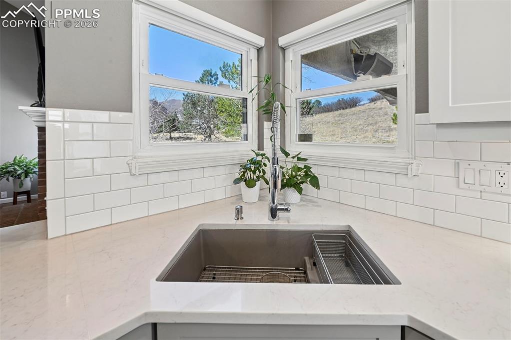 Kitchen view of light stone countertops and backsplash