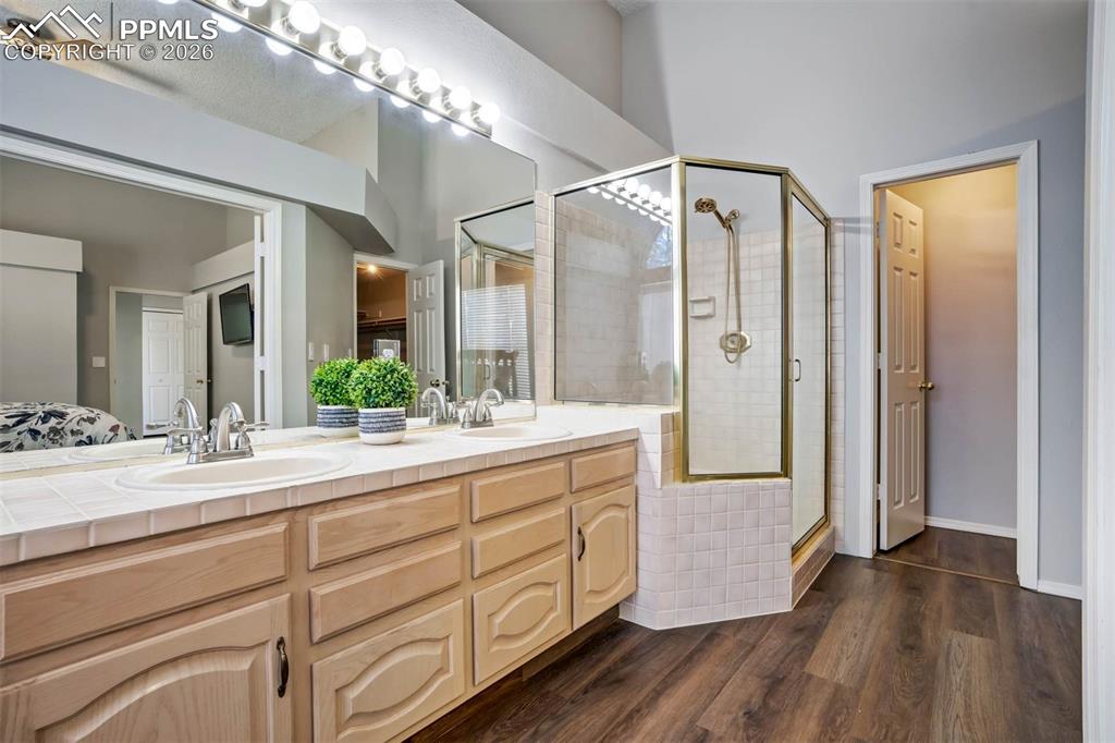 Bathroom featuring a shower, double vanity, and jet tub