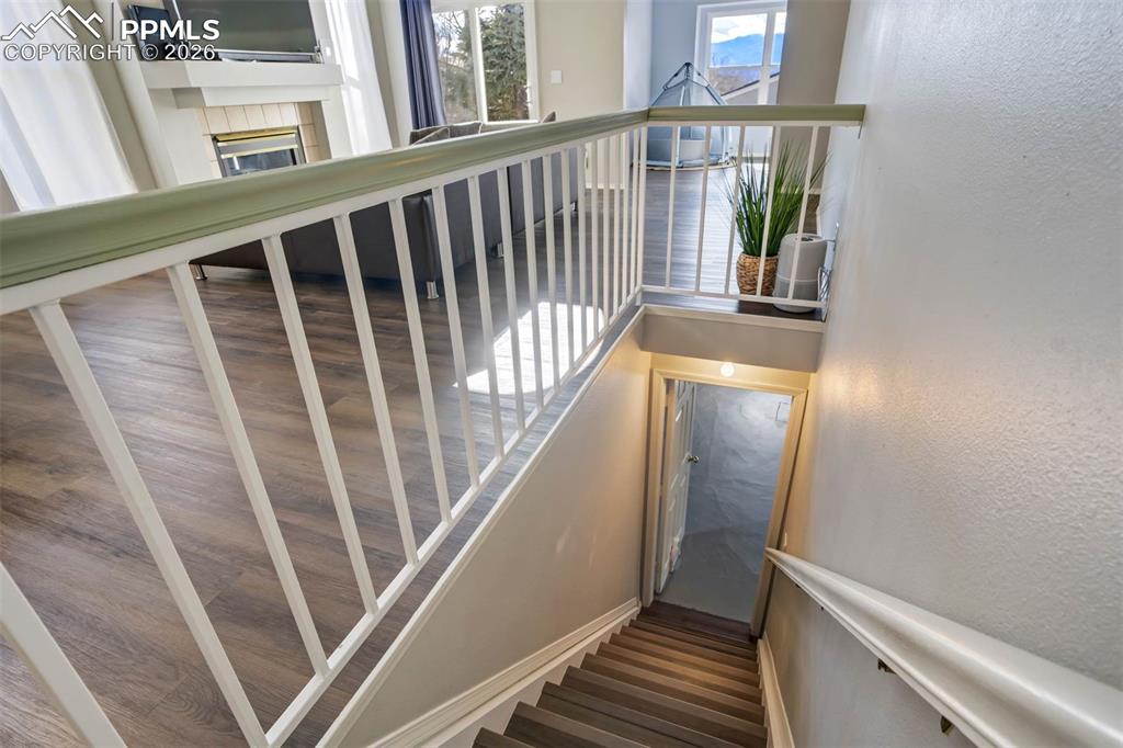 Stairway featuring a tiled fireplace and a textured wall