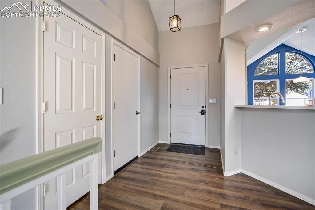 Entrance foyer with vaulted ceiling and dark wood finished floors