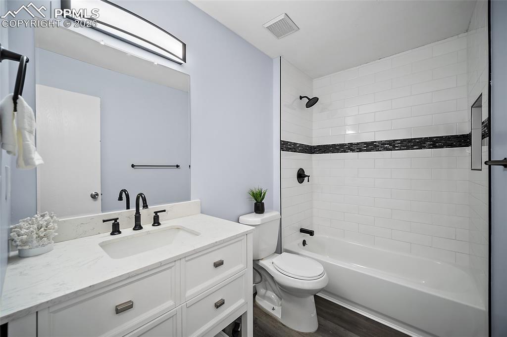 Full bathroom featuring vanity, shower/bathtub combination, and LVP flooring