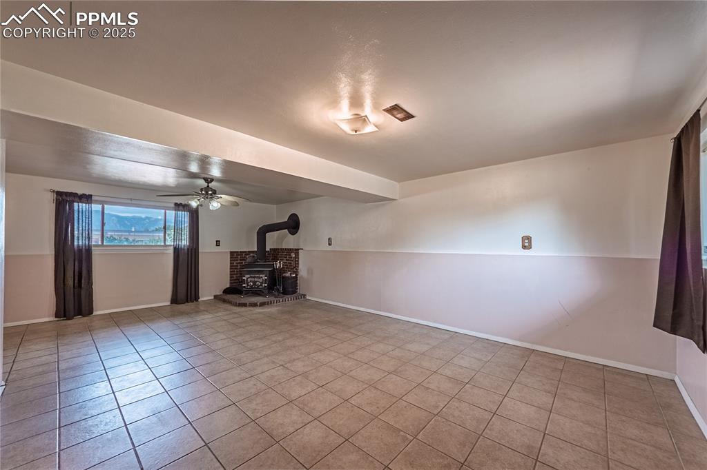 stove, ceiling fan, and light tile patterned flooring