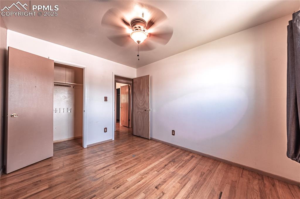 bedroom featuring wood finished floors, ceiling fan, and a closet