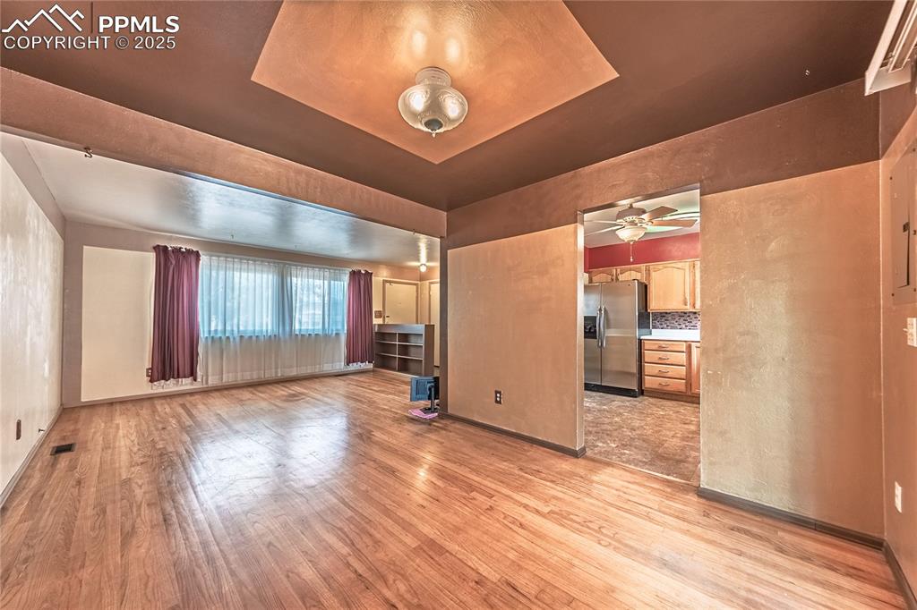  living room featuring light wood finished floors and a raised ceiling