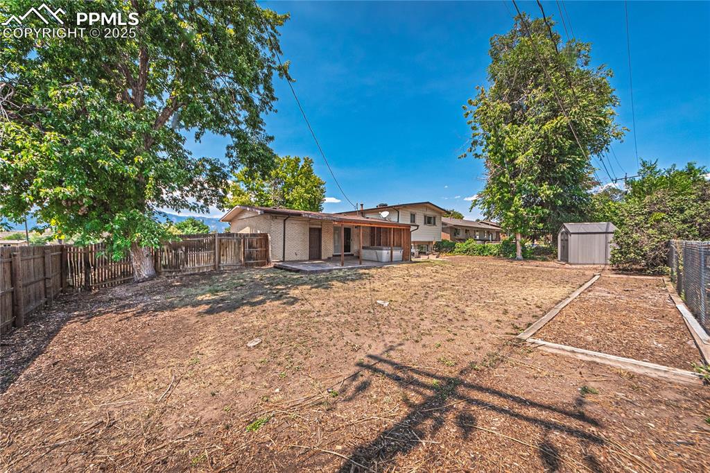 Fenced backyard with a patio and a shed