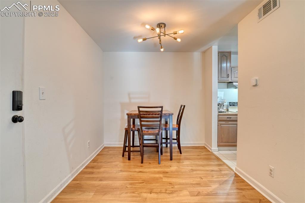 Dining area with a chandelier and light wood-style flooring