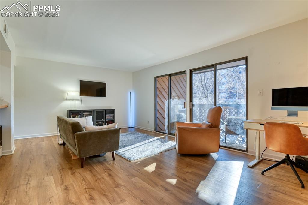 Living area with light wood finished floors and an office area